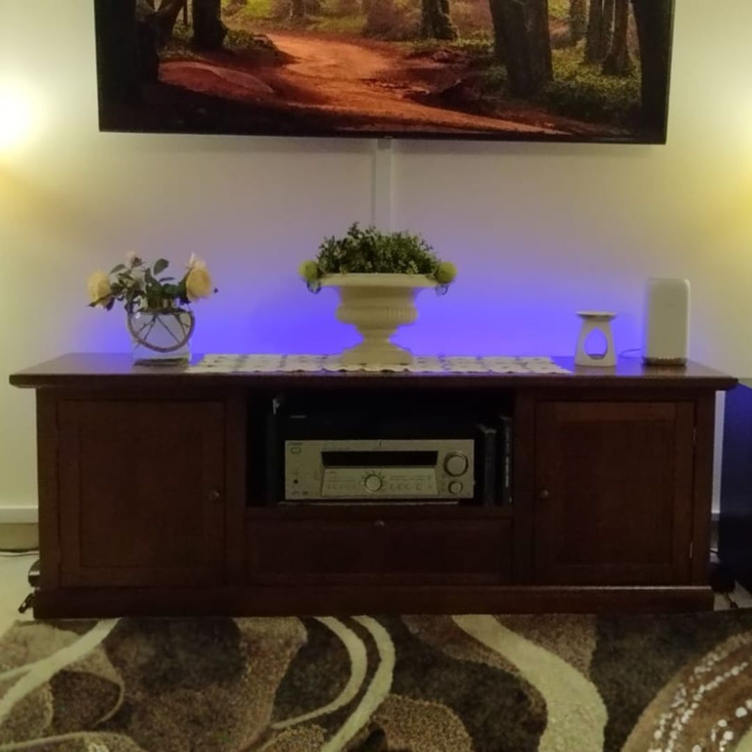 Mobile porta TV in legno noce con decorazioni e illuminazione LED blu.